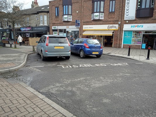 The blue badge parking spaces outside Cooplands, current occupied by cars