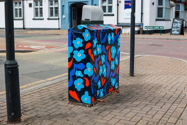 A painted utility box, painted red and blue flowers
