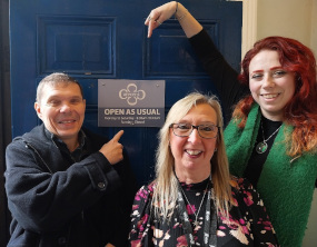 councillors jenny and alice pointing to an open as usual sign