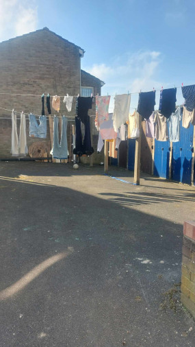 a concrete courtyard with clothes drying on a washing line