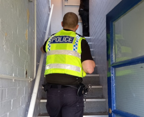 a policeman walking up a flight of stairs