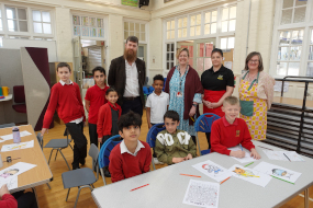 children smiling at the camera in Fishergate primary school with some staff standing behind them