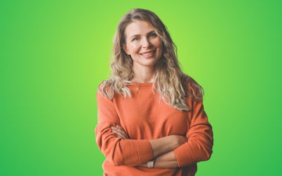 Health Trainers - Woman in orange jumper, smiling, with arms folded