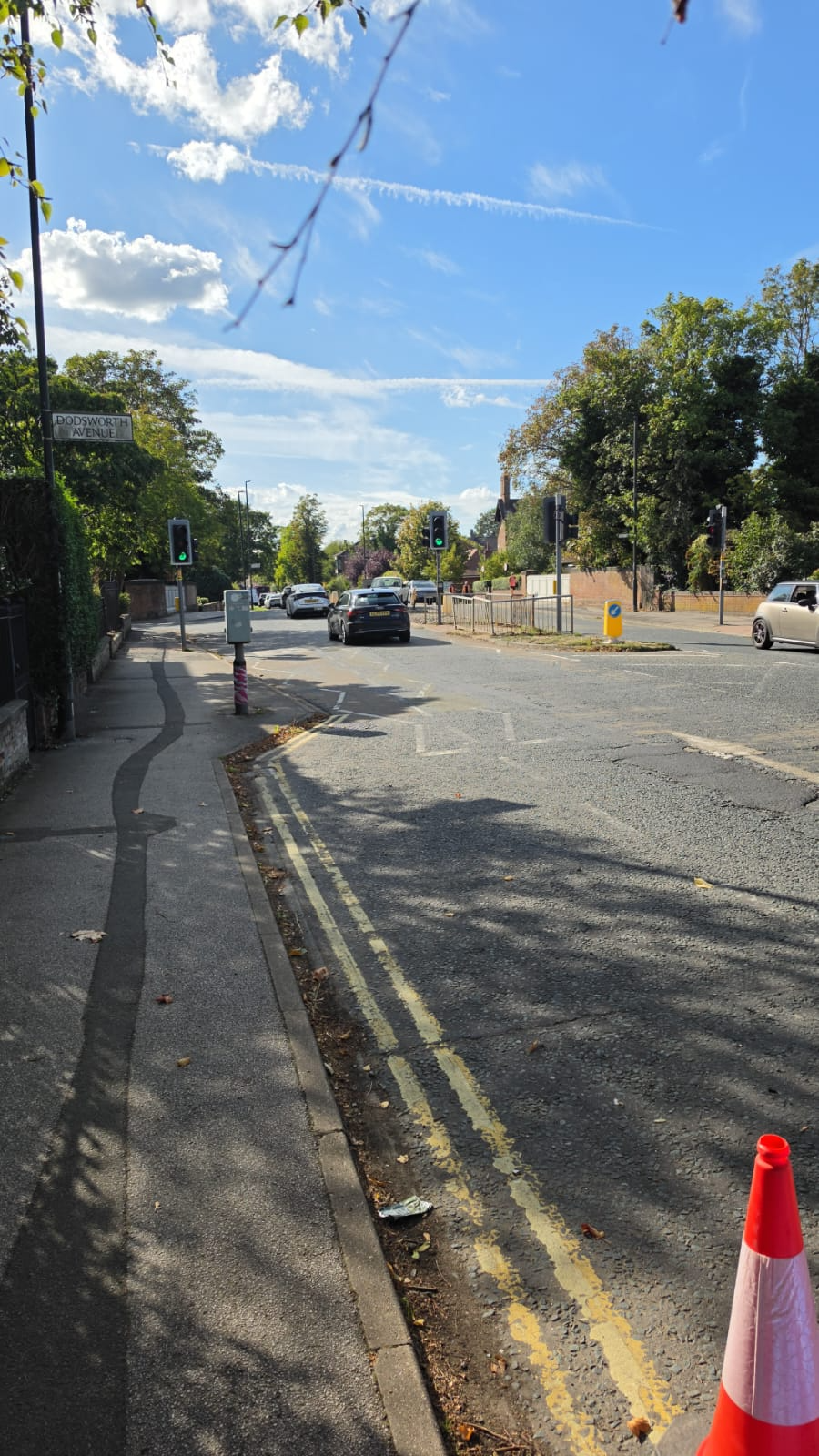 The picture shows Heworth Green, a main road, with traffic lights in the distance. A road sign on a post says Dodsworth Avenue.