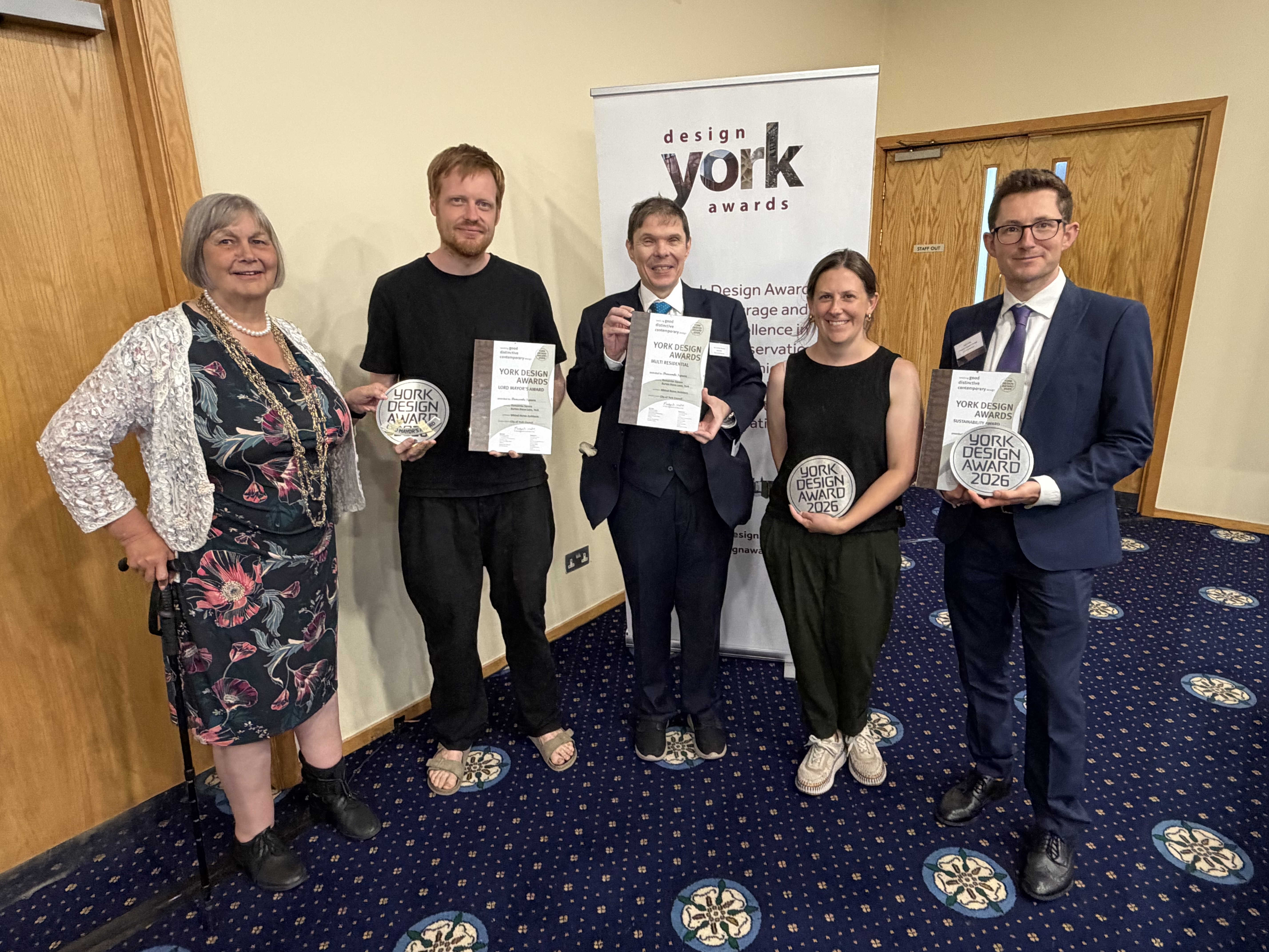 Five people line up with four holding York Design Award trophies