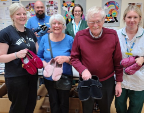 A group of people holding a range of slippers