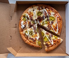 A pizza, with one slice cut, in an open carboard box