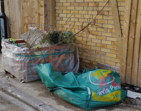 A large box and a bag of rubbish blocks a pavement