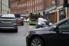 A single decker bus is stopped in traffic on Rougier Street, York, surrounded by cars