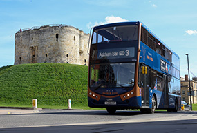 One of York's buses next to Cliffords Tower.