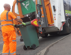 A man emptying a bin into a garden waste truck