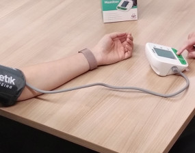 Blood pressure being taken from an arm which is lay flat on a table
