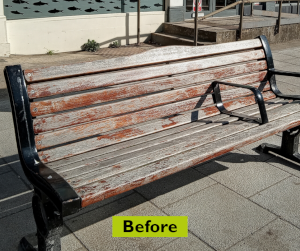 A bench before improvements has pealing paint
