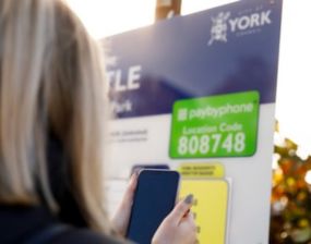 A person looking at a parking charges board