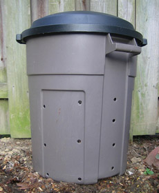 A composter made from a plastic bin with holes drilled around it.