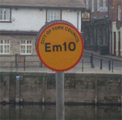 River Ouse emergency access point sign - circular yellow sign, with a red border and a code the centre