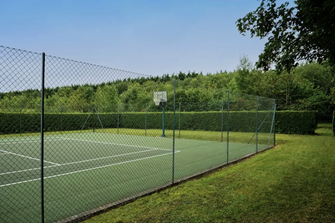 A tennis court. This image demonstrates the type of tennis court design which may be implemented at the Fulford Recreational Development Proposal. It shows a tennis court surrounded by a low hedge.