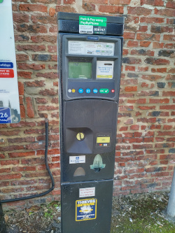 Car parking ticket machine against wall