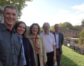 A group of people stand on the city walls with the Willow House in the background