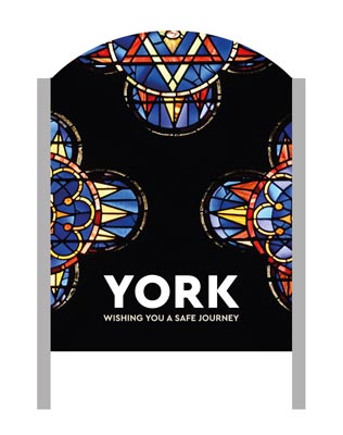 A 'Make It York' welcome sign with a stained glass window design in the background.