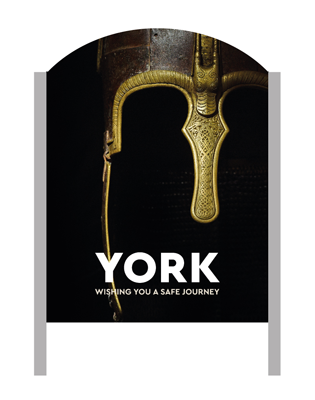 A 'Make It York' welcome sign with an Anglo Saxon helmet in the background.