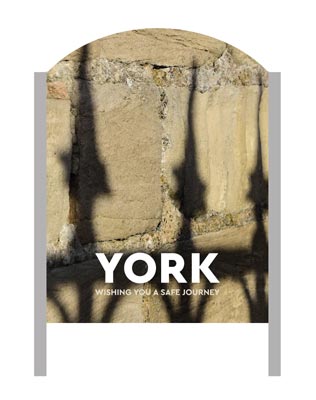 A 'Make It York' welcome sign with the York City wall in the background.