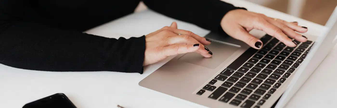 A close up of a lady using a laptop.